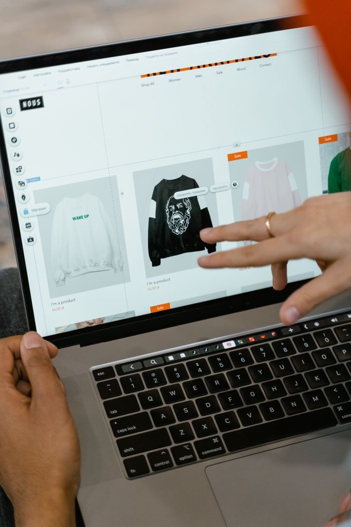 The Art of Drawing Readers In: Your attractive post title goes here Close-up of hands interacting with a shopping website on a laptop screen indoors.